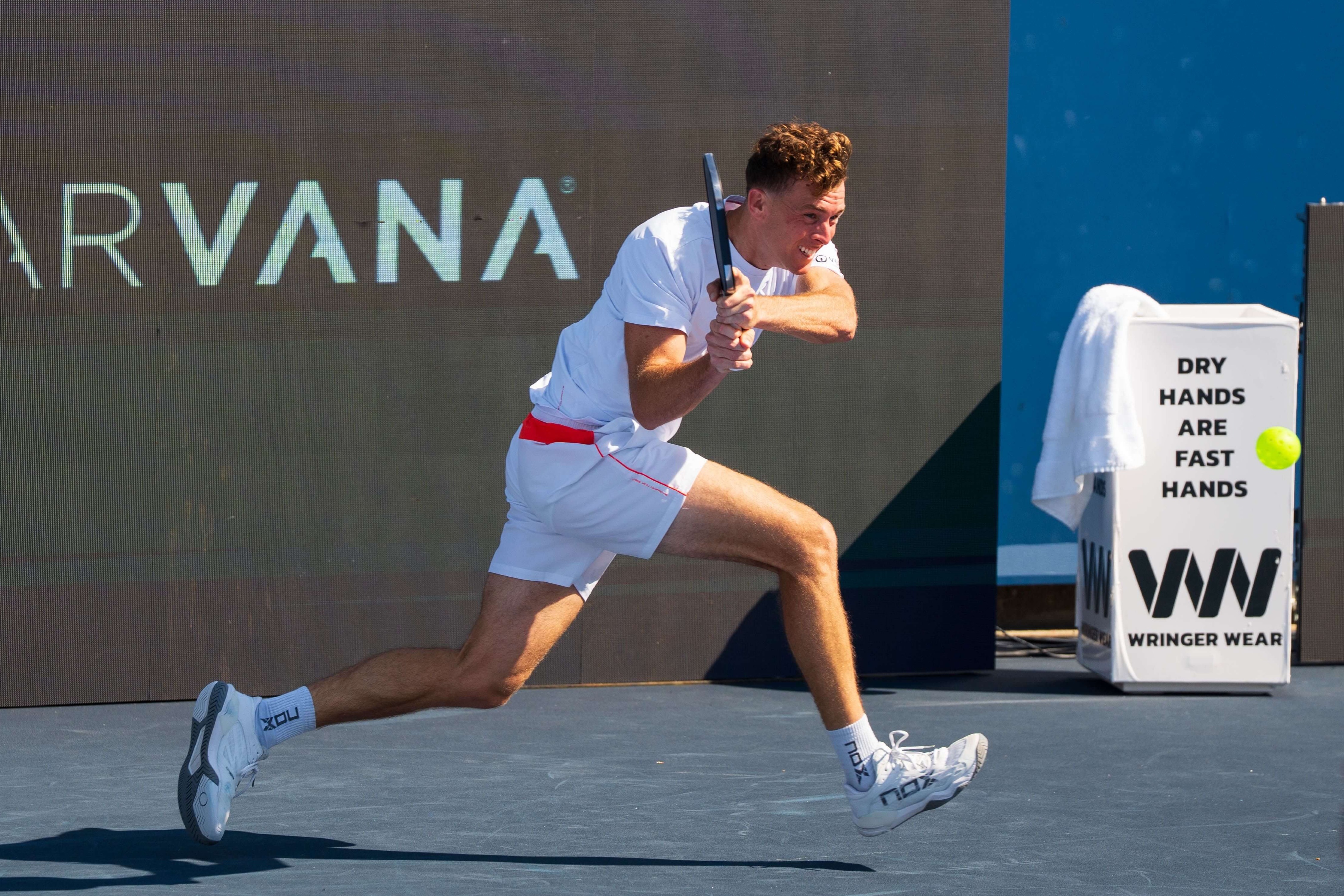 Grayson in white outfit with red stitching